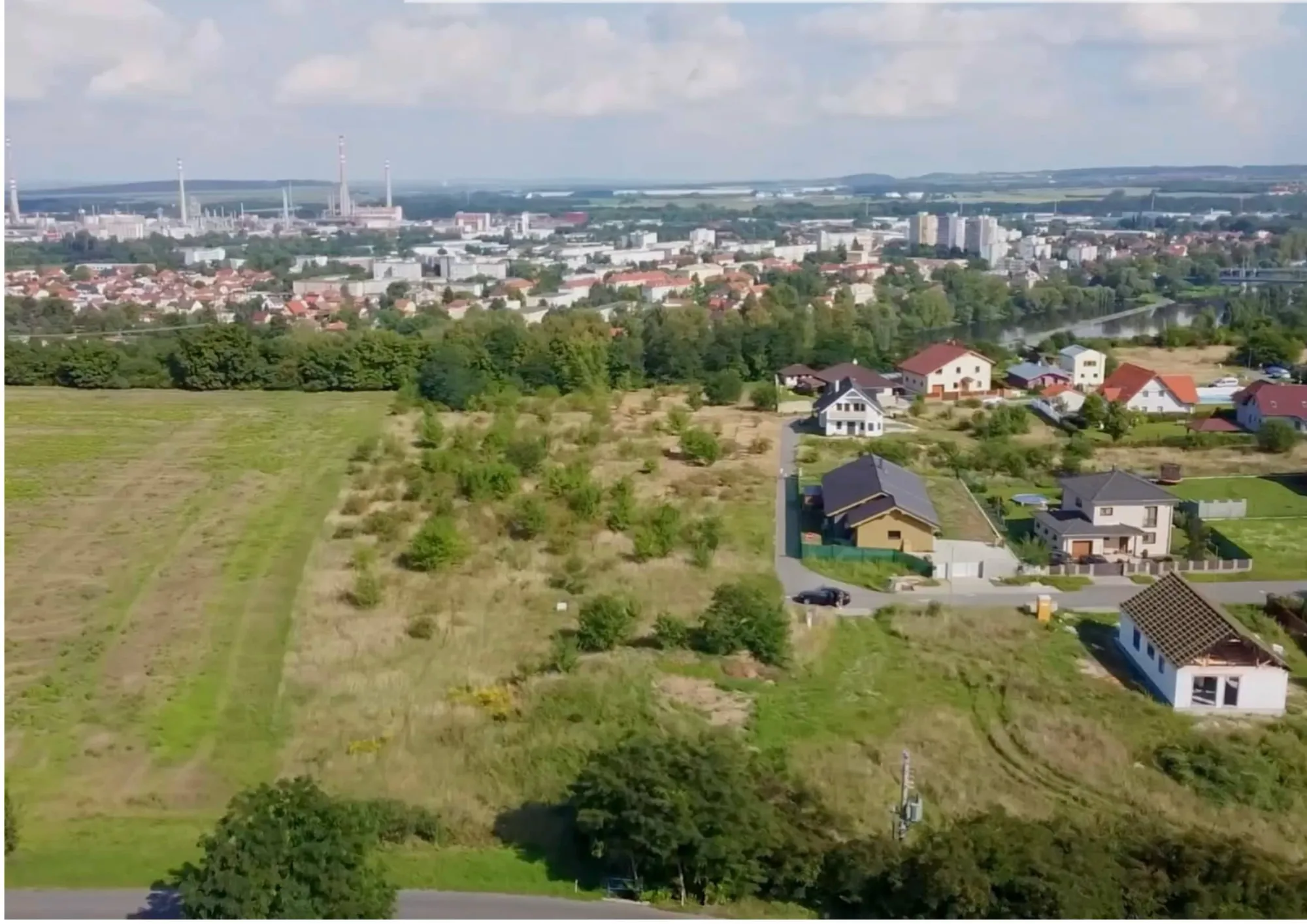 Letecký pohled přes pozemky na Kralupy nad Vltavou a řeku